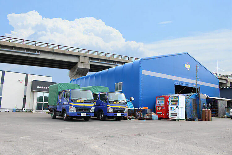 志向産業株式会社の社屋と作業車両